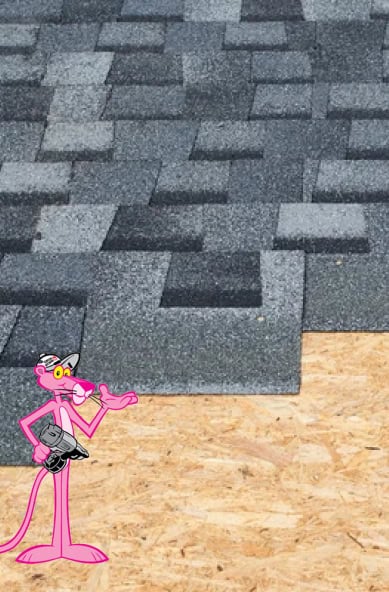 A cartoon pink panther character stands on plywood near an unfinished roof with gray asphalt shingles partially installed, showcasing Clover Roofing’s craftsmanship in South Carolina.